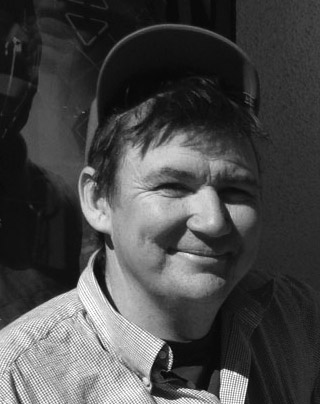 Headshot of the artist Larry Bob wearing a hat and smiling at the camera.