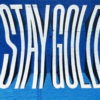 mural of fish-eyed letters reading stay gold